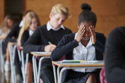 Anxious Teenage Student Sitting Examination In School Hall